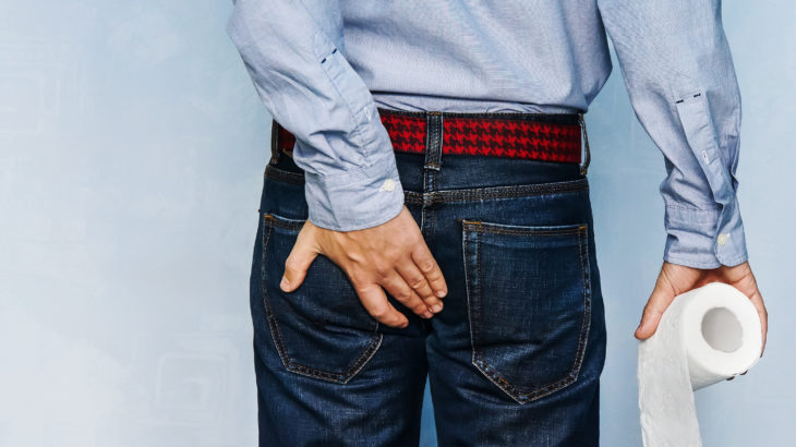 Un homme souffre des hémorroïdes et se tient les fesses